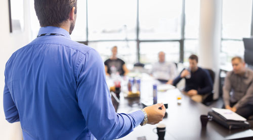 Man doing a speech to his colleagues during a meeting in an office