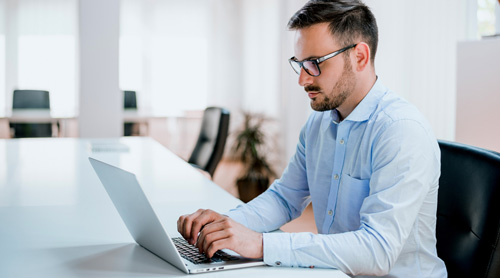 Man with glasses using a laptop